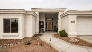 A two-story house with a front entrance, a garage, and a small front yard. - Havasu Jamaica S - Pool, Spa, Casita, Central (Lake Havasu City)