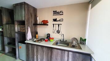 Suite estudio ejecutiva, balcón, vista a la ciudad | Cocina privada | Frigobar, microondas, licuadora y molino para café