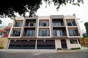 Un edificio de varios pisos con tres puertas de garaje identificadas como G1, G2 y G3.