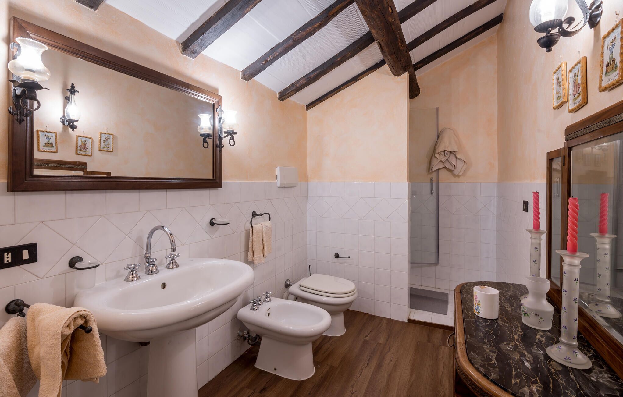 A bathroom with a sink, bidet, toilet, and shower.