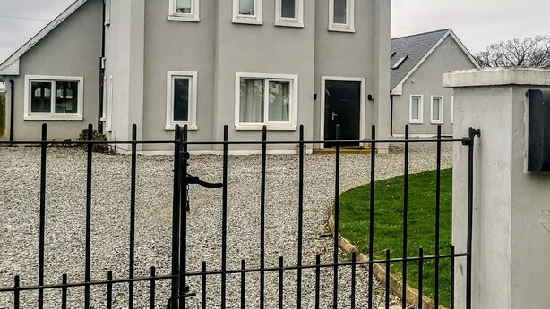 A two-story house with a grey facade, white trim, and a visible chimney. - 2 bedroom house near Athy, 45 minutes by train to Dublin (Athy)
