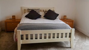 A single bed with a headboard, two bedside tables, and a power outlet on the wall. - 2 bedroom house near Athy, 45 minutes by train to Dublin (Athy)