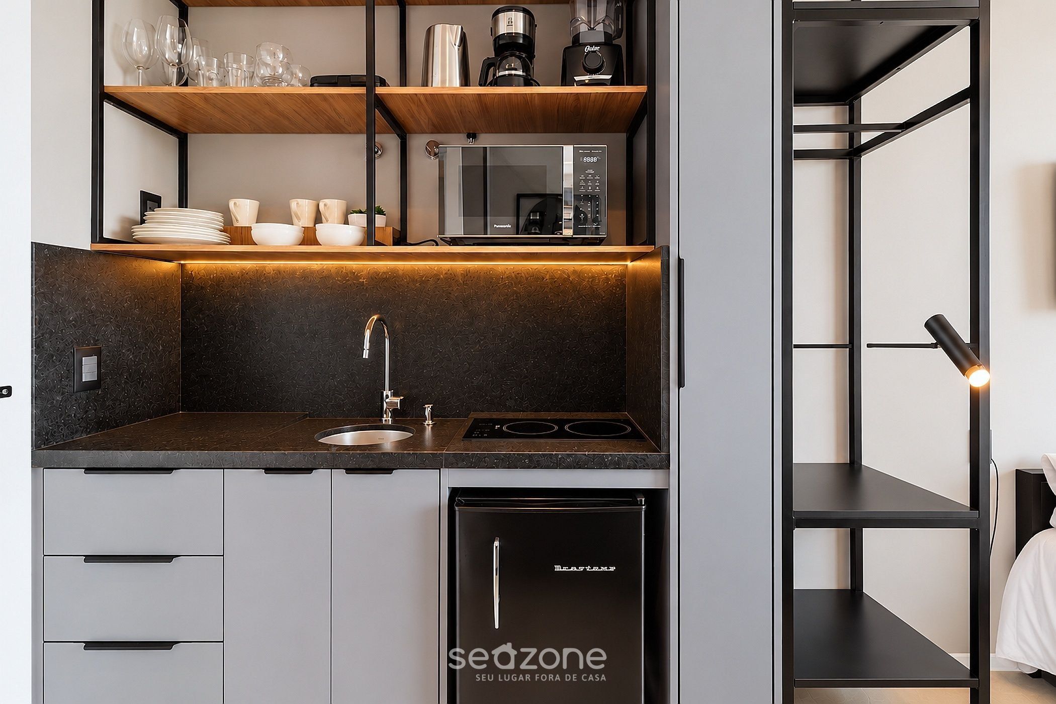 A modern kitchen with a built-in microwave, a coffee maker, and a dishwasher.