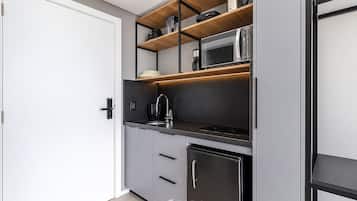 Una cocina moderna equipada con microondas, cafetera y refrigerador.
