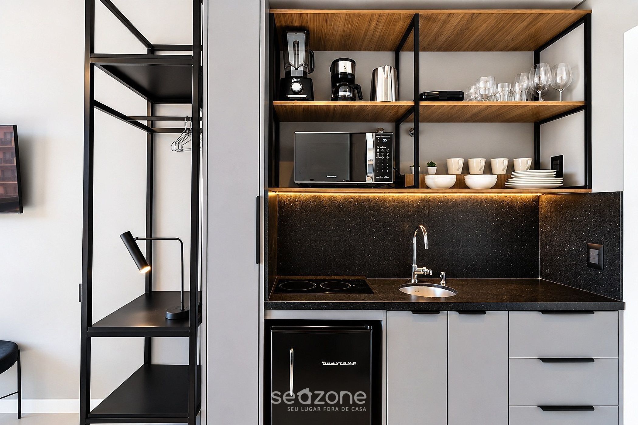 A modern kitchen with a built-in microwave, coffee maker, and a sink.