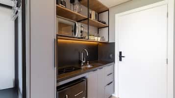 Una cocina compacta con horno empotrado, lavamanos y lavavajillas.