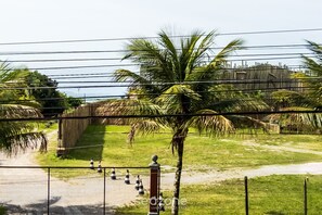 A fenced outdoor area with palm trees and a wooden fence in the background. - Spot Jurere sofisticação beira mar SPJs (Florianópolis)