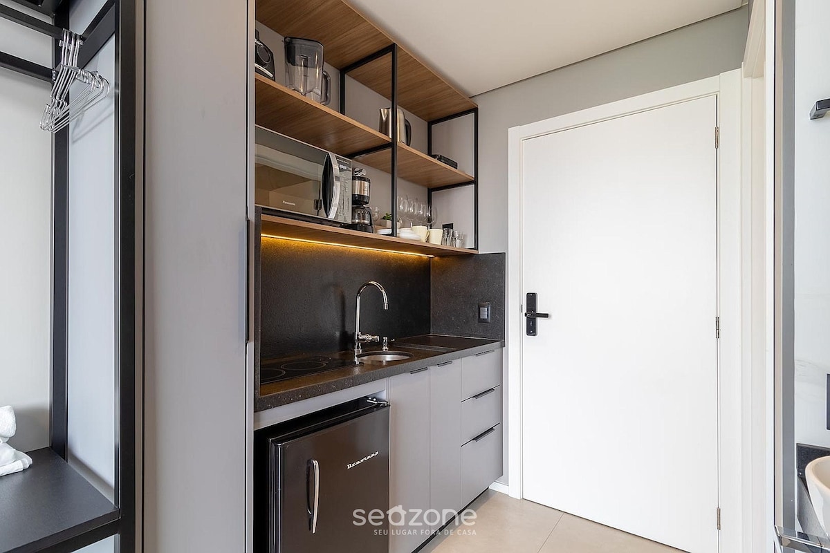 A modern kitchen with a built-in oven, a sink, and a coffee machine.