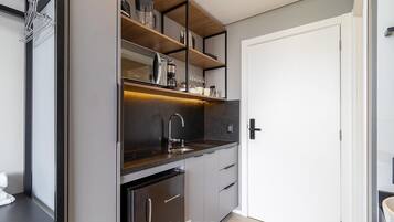 A modern kitchen with a built-in oven, a sink, and a coffee machine.