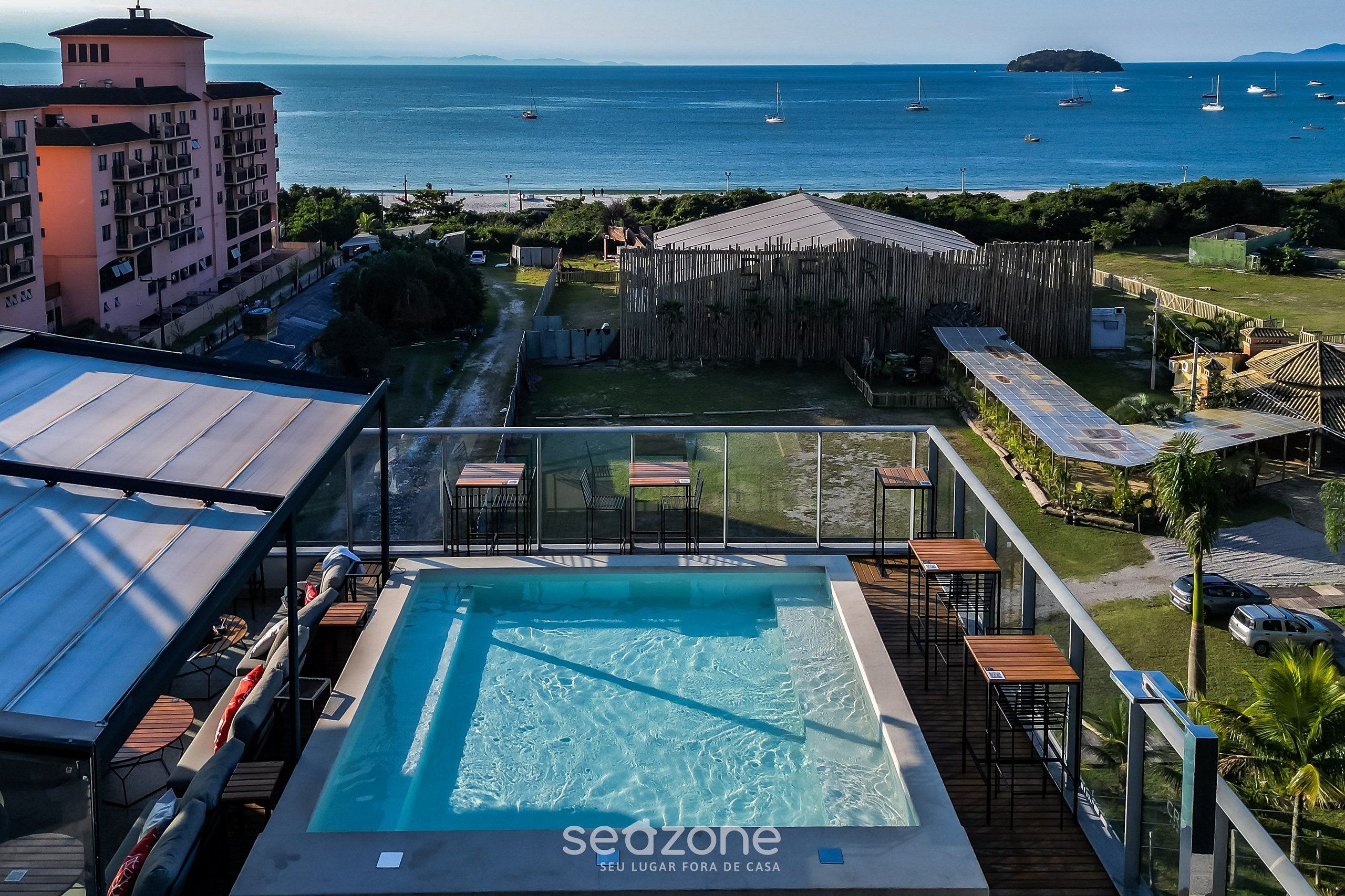 A rooftop pool with a view of the sea and boats.