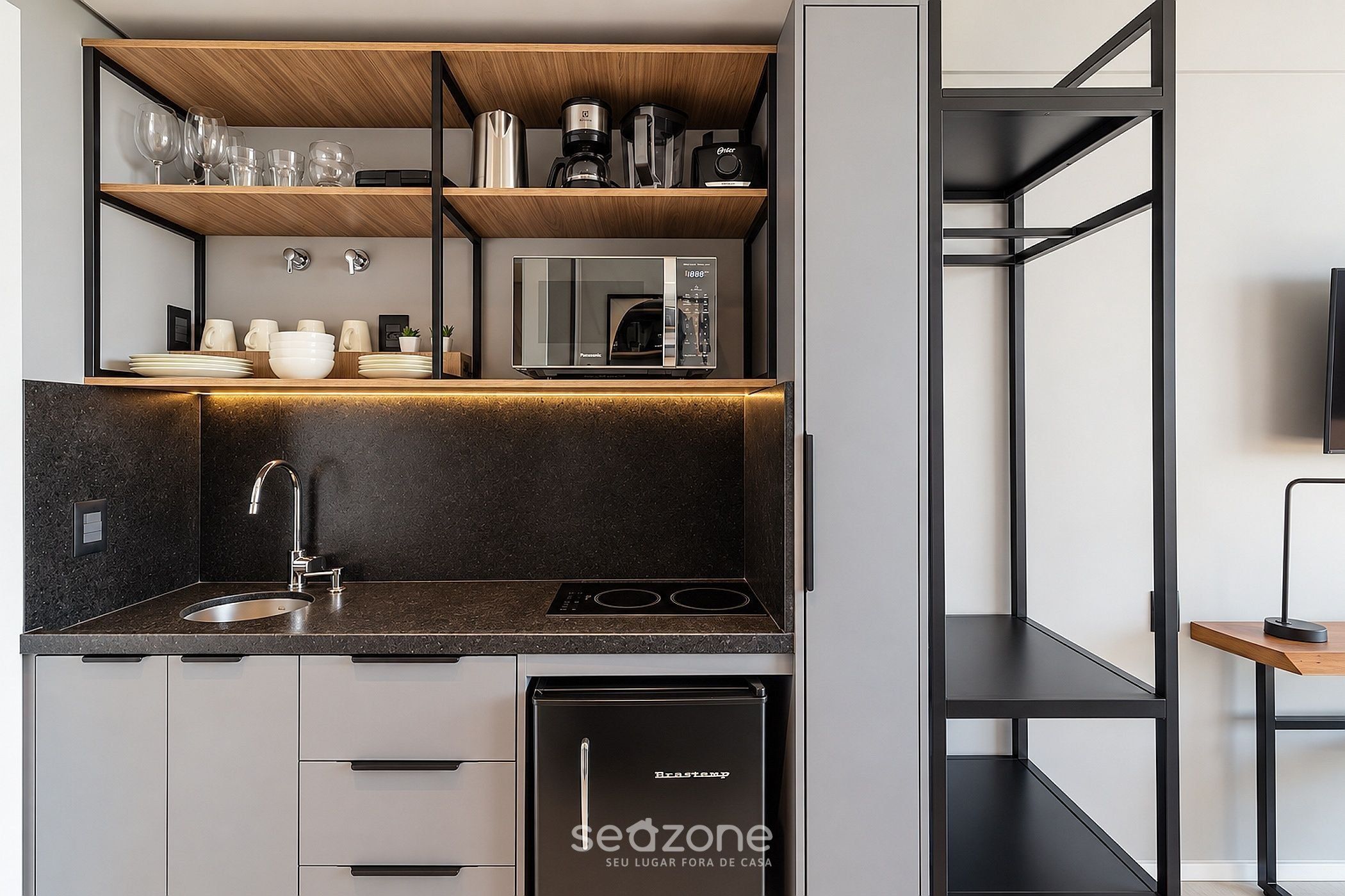 A compact kitchen with a built-in dishwasher, a coffee maker, and a compact refrigerator.