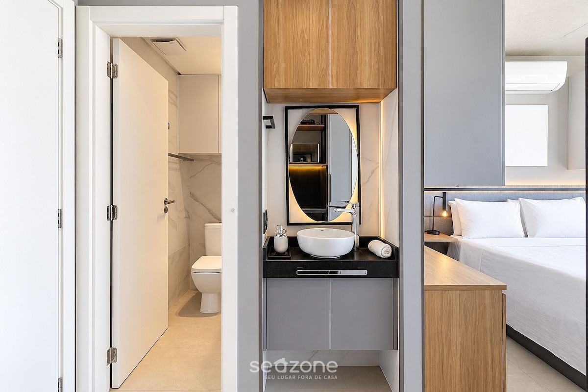 A modern bathroom with a toilet, sink, and mirror.