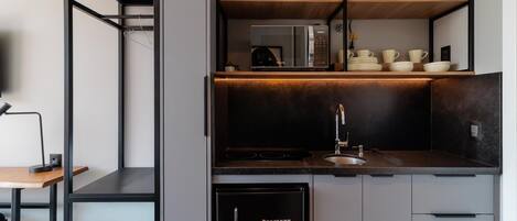 A modern kitchen with built-in appliances, a sink, and a dining area with a table and chair.
