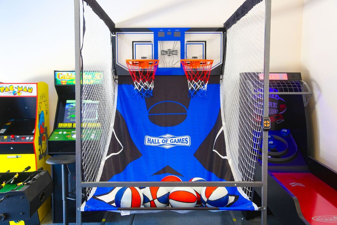 A basketball arcade game with two hoops and a "Hall of Games" sign.