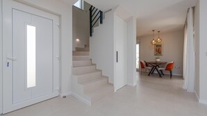 A modern interior with a staircase, a dining area, and a door with a keyhole. - Beach front home in Sukosan (Sukosan)