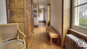 A hallway with wooden paneling, a bench, and a radiator. - Château de Montclair (POMMIERS)