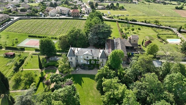 An aerial view of a large estate with a central building surrounded by well-maintained gardens and fields. - Château de Montclair (POMMIERS)