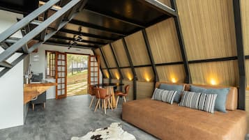 Ein modernes Interieur mit einer Couch, Essbereich und Treppe.