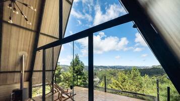A modern interior with a large window overlooking a lush landscape.