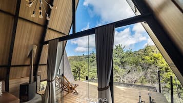 A modern interior with a large window, a wooden ceiling, and a view of the outdoors.