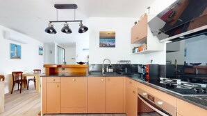 Une cuisine moderne dotée d’un îlot central, d’un four encastré et d’un grand réfrigérateur de la marque Bosch.