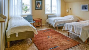 A room with two single beds, a chair, a radiator, and a window with curtains. - 5 bedroom nice home in Kilsmo (Kilsmo)