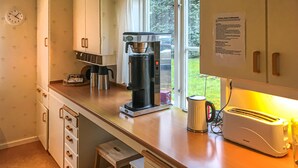 A kitchen with a coffee machine, a toaster, and a window with a view of greenery. - 5 bedroom nice home in Kilsmo (Kilsmo)