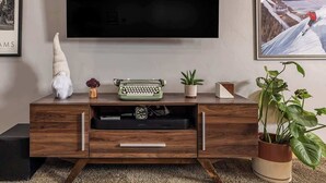 Un mueble de madera para entretenimiento con un televisor de pantalla plana montado encima.