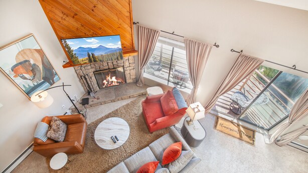 Ein gemütliches Wohnzimmer mit Kamin, bequemen Sitzmöglichkeiten und einem großen Fenster mit schöner Aussicht.