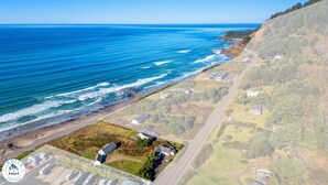 Vista aérea de uma área costeira com uma estrada bem definida, uma praia e edifícios residenciais.
