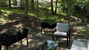 An outdoor seating area with a table, chairs, and a planter. - Walk to Town, Beach, Game Room, Firepit Stay (New Buffalo)