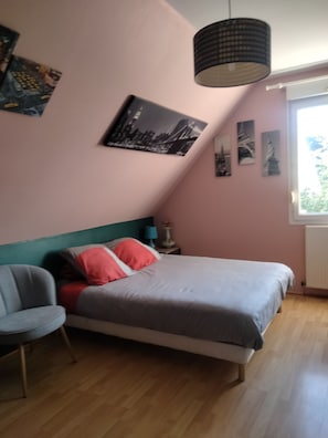 A bedroom with a bed, a chair, a lamp, and wall art. - Chambre D'hôtes Pour Vacances ou des Événements Comme le Circuit, Antarès (Teloché)