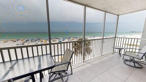 A balcony with a view of a beach, a table, and two chairs. - Crescent Arms Vacation Rentals 301S Siesta Key Florida (Siesta)