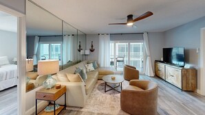 Une chambre d’hôtel moderne avec un grand lit, un canapé, une table basse et un téléviseur.