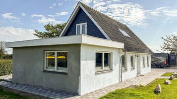 A modern house with a sloped roof, a small attached garage, and a paved driveway.