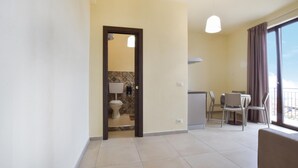 A spacious living area with a balcony, a dining area, and a bathroom with patterned tiles. - Stunning apartment in Patti with WiFi (Patti)