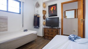 A bedroom with a single bed, a TV, a wooden dresser, and a window. - 2 bedroom lovely apartment in Miramar (Miramar)