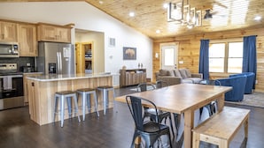 Una cocina amplia con armarios de madera, un refrigerador y un comedor con una mesa y sillas de madera.