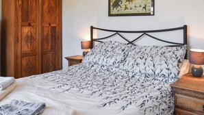 A bedroom with a bed, wooden wardrobe, nightstands, and a framed picture on the wall. - 2 bedroom accommodation in St Clether, near Launceston (St Clether, near Launceston)
