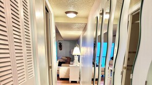 A hallway with wooden flooring, white doors with louvered tops, and a mirror on the right wall. - Breathtaking Ocean view, few steps to the beach!!!!! (Ocean City)