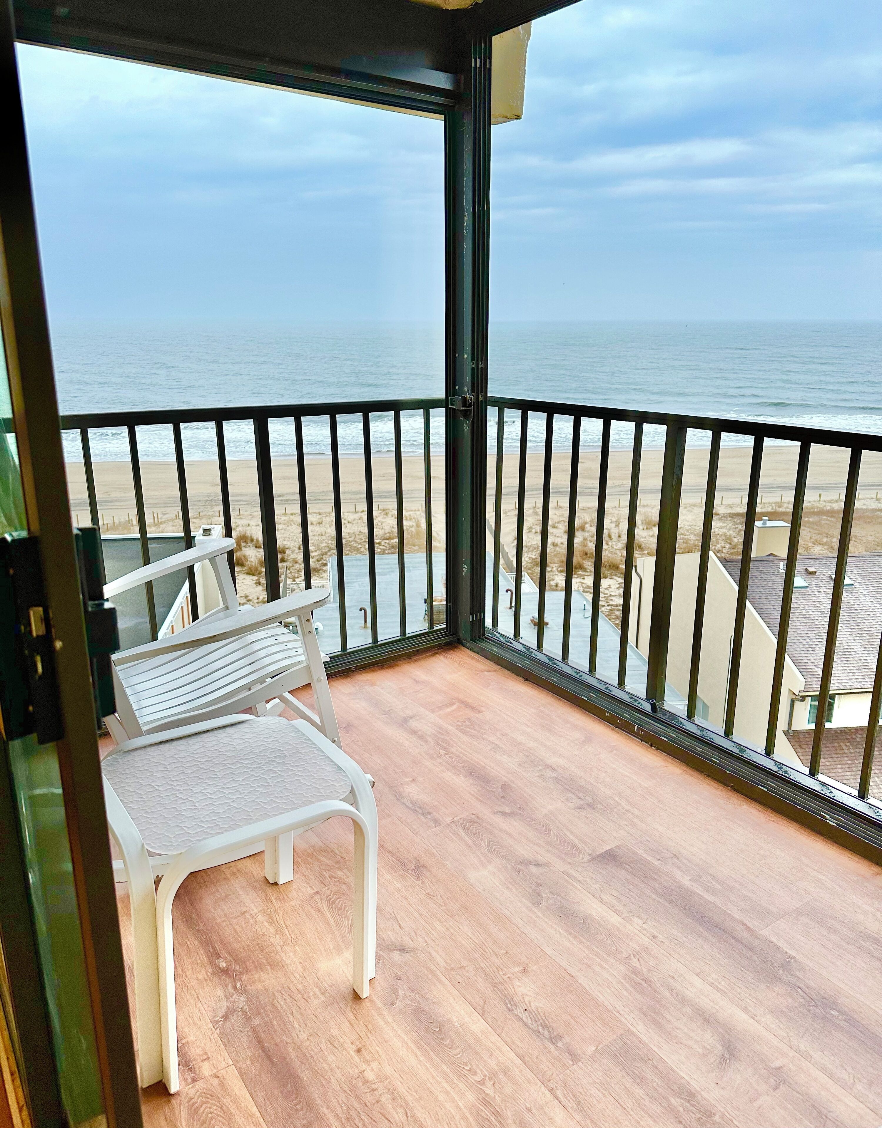 Un balcón con vista a la playa y el océano.