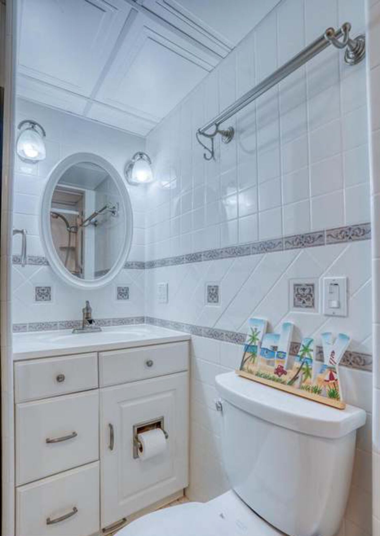 A bathroom with a white vanity, a toilet, and a shower area.