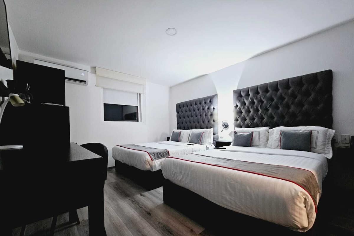 Una habitación de hotel moderna con dos camas, un escritorio y una silla.