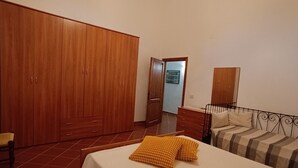 A bedroom with a bed, a wardrobe, a nightstand, and a chair. - Spacious apartment strategically located for visiting Siena and province (Sovicille)