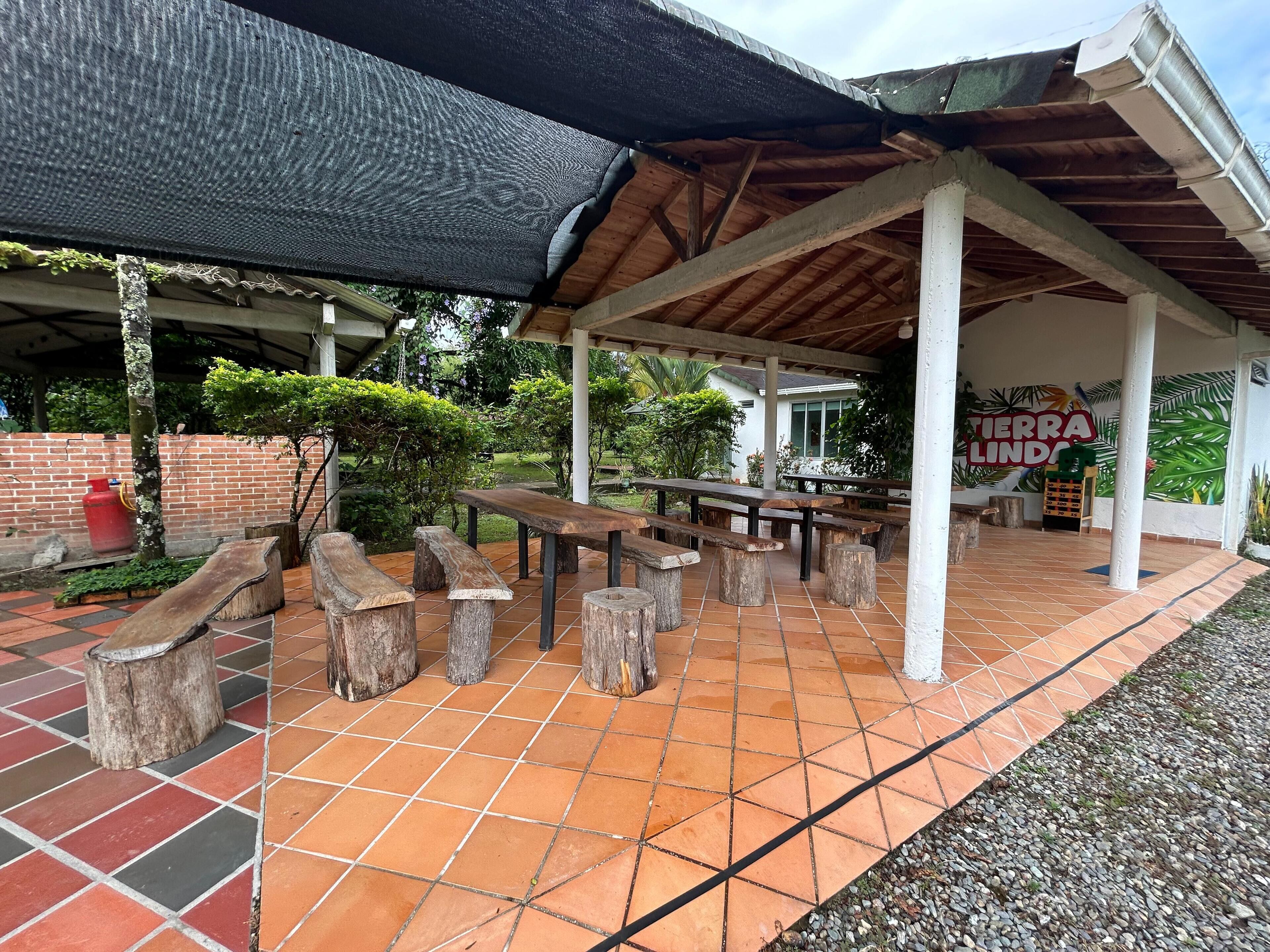 Un patio al aire libre con bancos de madera y suelo de baldosas.