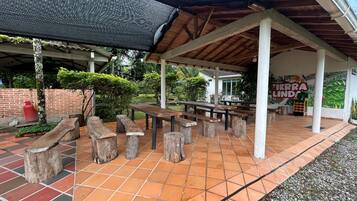 Un patio al aire libre con bancos de madera y suelo de baldosas.