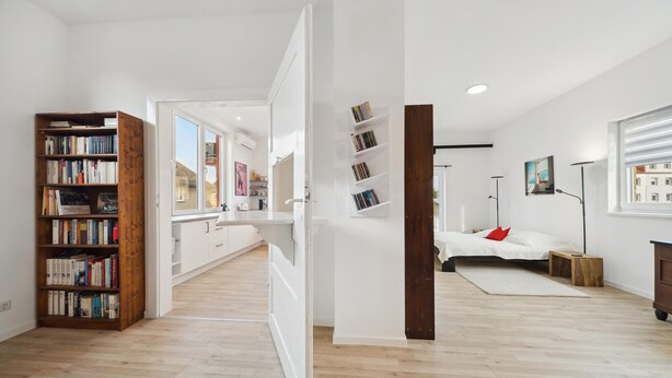 Ein moderner, offener Wohnbereich mit Küche, Essbereich und Schlafzimmer.