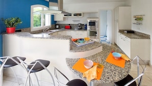 A modern kitchen with granite countertops, stainless steel appliances, and a central island with seating. - Beautiful home in Léon (Léon)