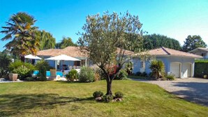 A residential area with a house featuring a tiled roof, a swimming pool, and a well-maintained lawn. - Beautiful home in Léon (Léon)