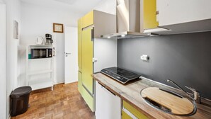 A compact kitchen with a microwave, coffee maker, and a built-in stove.